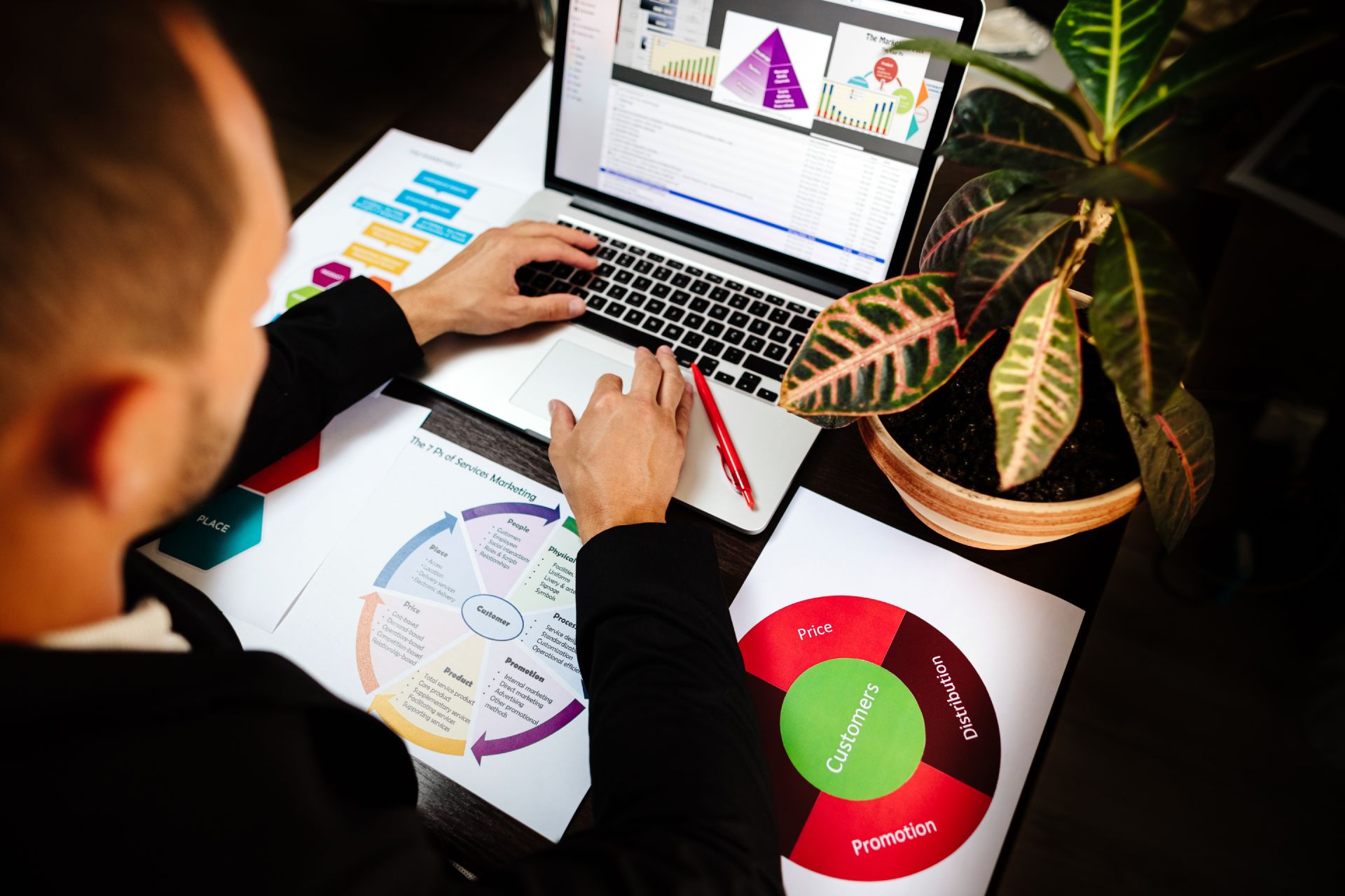 Man looking at report graphics on desk and laptop