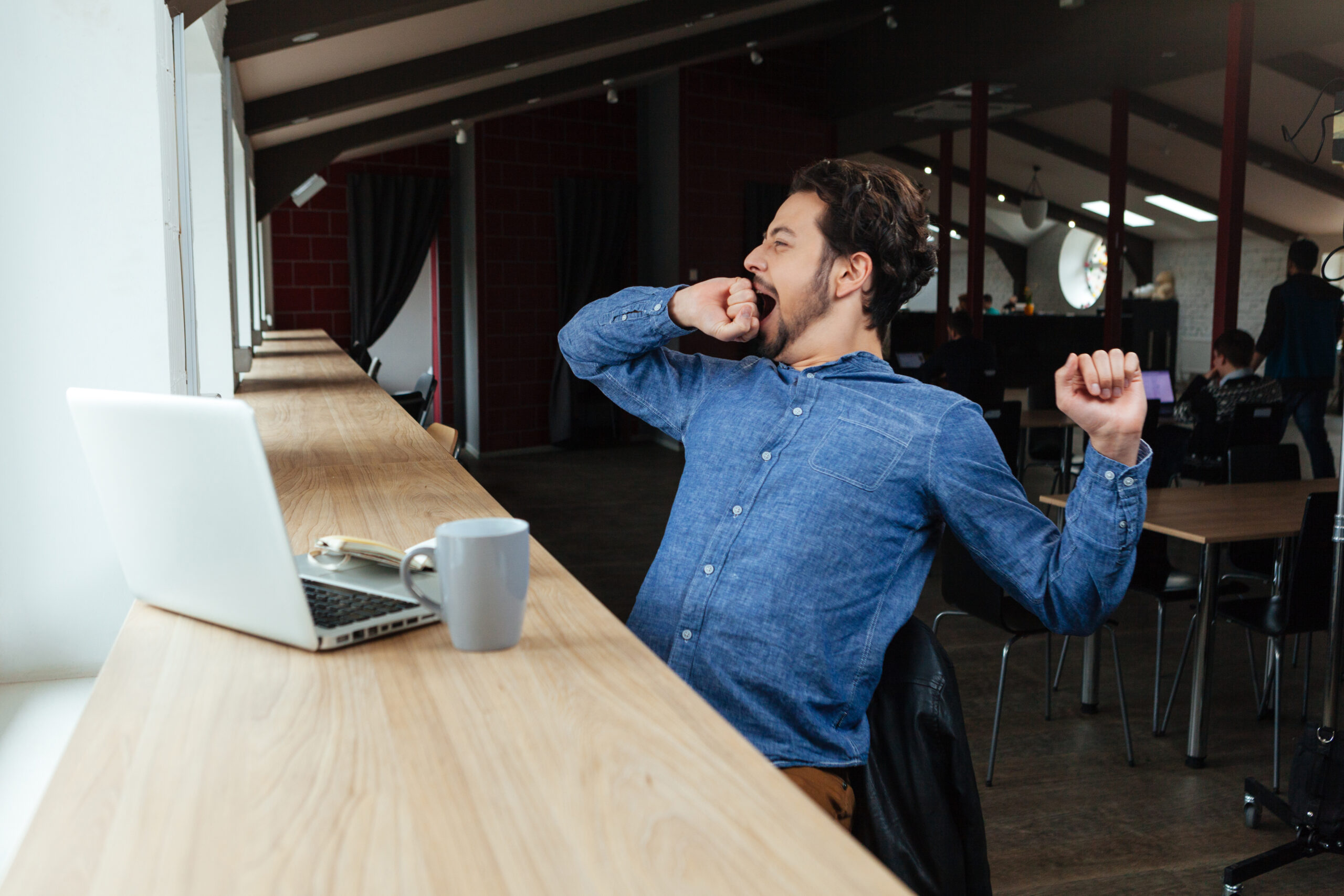 content strategy man yawning in a cafe