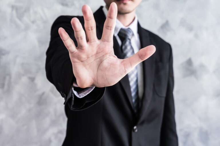 marketing friction man in suit holding up palm