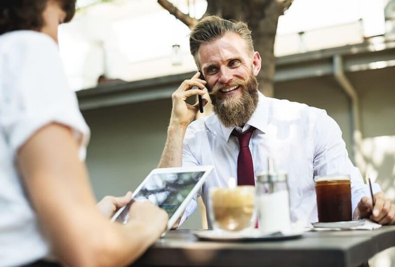 close deals man with beard on phone